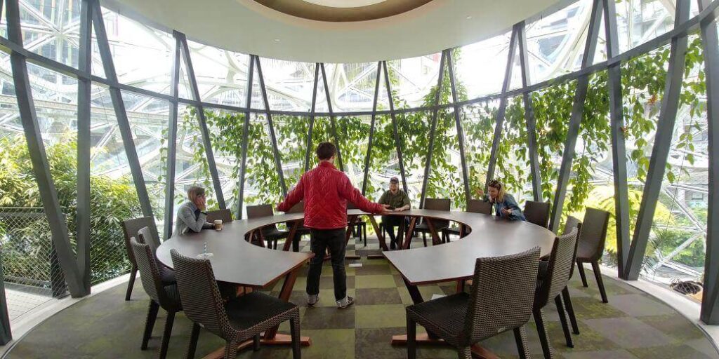 A sleek meeting room design with modern furniture and lush greenery inside the Amazon Spheres.