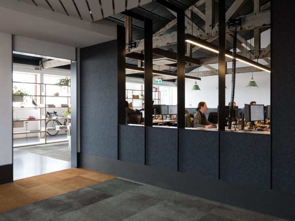 Acoustic panelling installed on a wall to reduce noise and improve sound quality in a modern office setting.